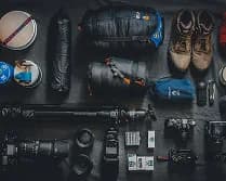 Camping gear flat-lay with pack, mug, and stove